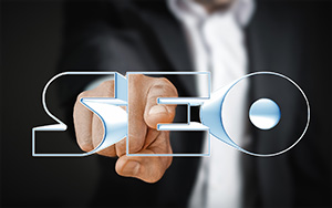 Business person pointing at metallic letters "SEO"