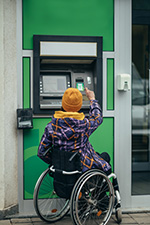 Person in wheelchair using ATM showing how accessibility matters