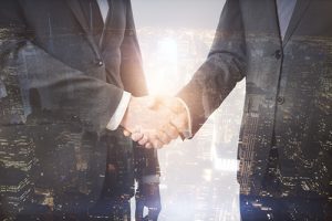 ATM vendor in NJ and branch manager shake hands with a glowing cityscape overlayed