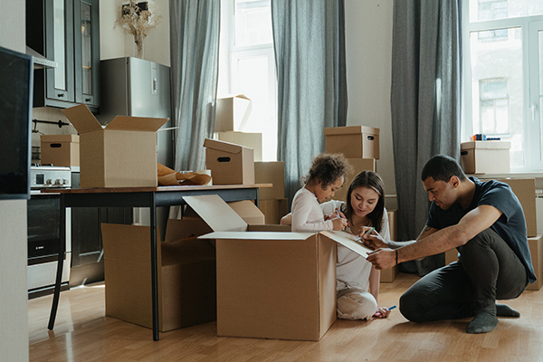 Family surrounded by packing boxes while moving to the Seaside Park real estate market